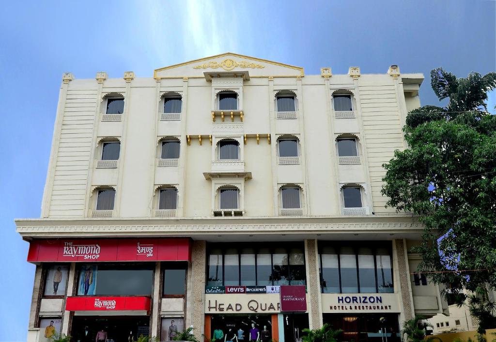 Horizon Hotel في أودايبور: مبنى ابيض كبير على شارع المدينة