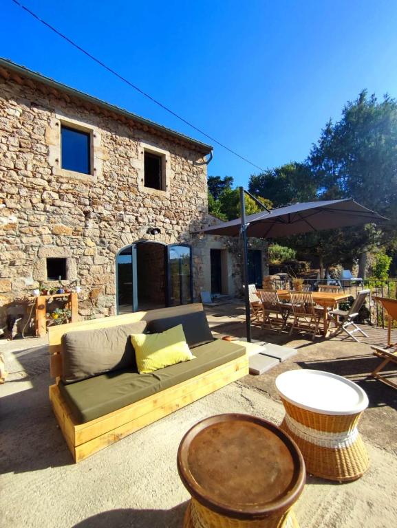 - un patio avec un canapé et une table dans l'établissement L'Atelier des Huppes, à Joyeuse