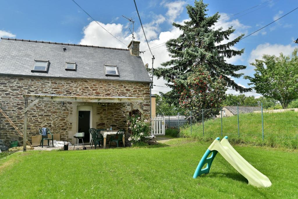 un patio con un tobogán delante de una casa en La Jouvence - Maison à 10min de la mer, en Créhen