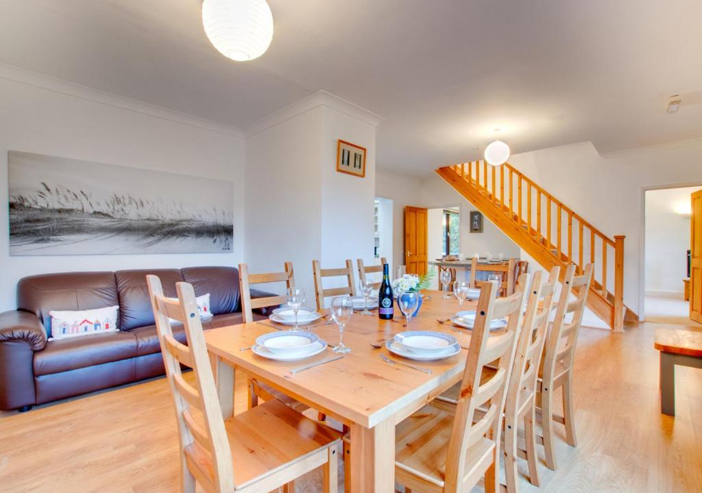 a dining room and living room with a wooden table and chairs at Dirleton in Saundersfoot