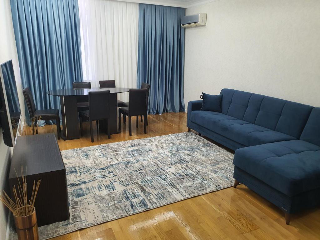 uma sala de estar com um sofá azul e uma mesa em Viva 3 room apartment with jacuzzi two kilometers from the center em Baku