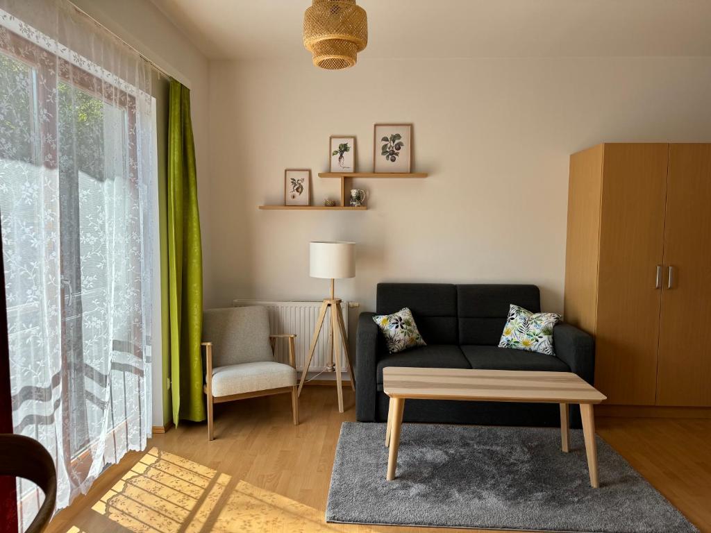 salon z kanapą i krzesłem w obiekcie Lindenhof Deutsch w mieście Bad Tatzmannsdorf
