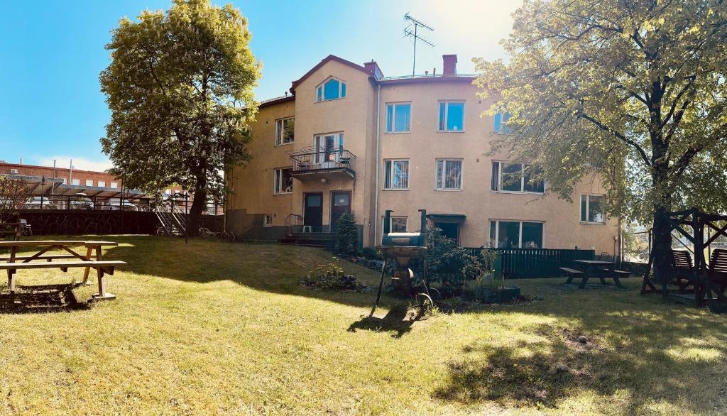 un grande edificio con un tavolo da picnic nel cortile di B&B Retro - Guesthouse Kupittaa a Turku