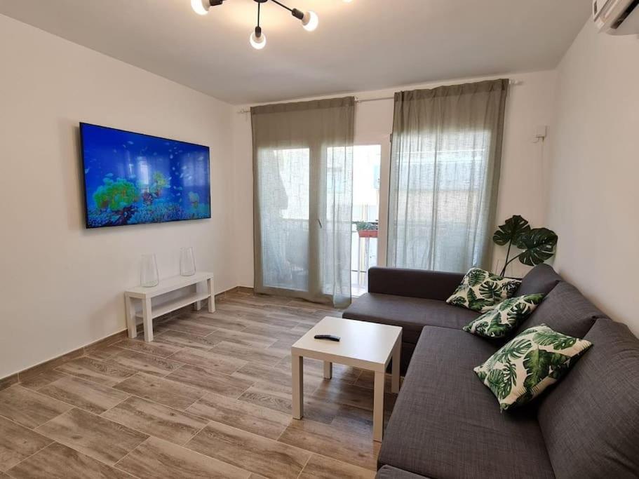 a living room with a couch and a table at Precioso Apartamento Acondicionado al Lado del MAR in Calafell