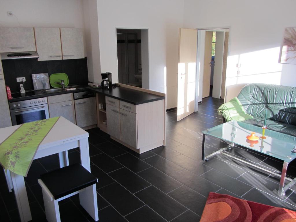 eine Küche und ein Wohnzimmer mit einem Sofa und einem Tisch in der Unterkunft Ferienwohnung Am Alten Forsthaus Neuenbau in Neuenbau