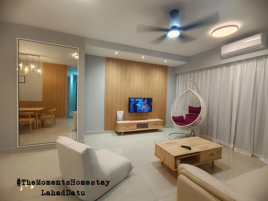 a living room with a couch and a tv at The Moments Homestay in Lahad Datu
