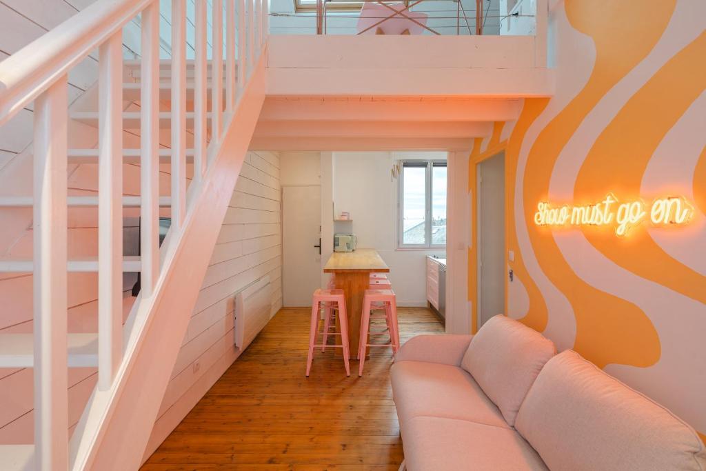 un salon avec un canapé et un escalier dans l'établissement Appartement coloré proche du centre ville et de la gare, à Deauville