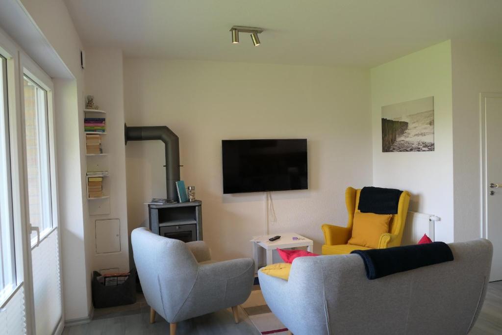 a living room with two chairs and a tv at Ferienhaus 6969 in Tossens in Tossens