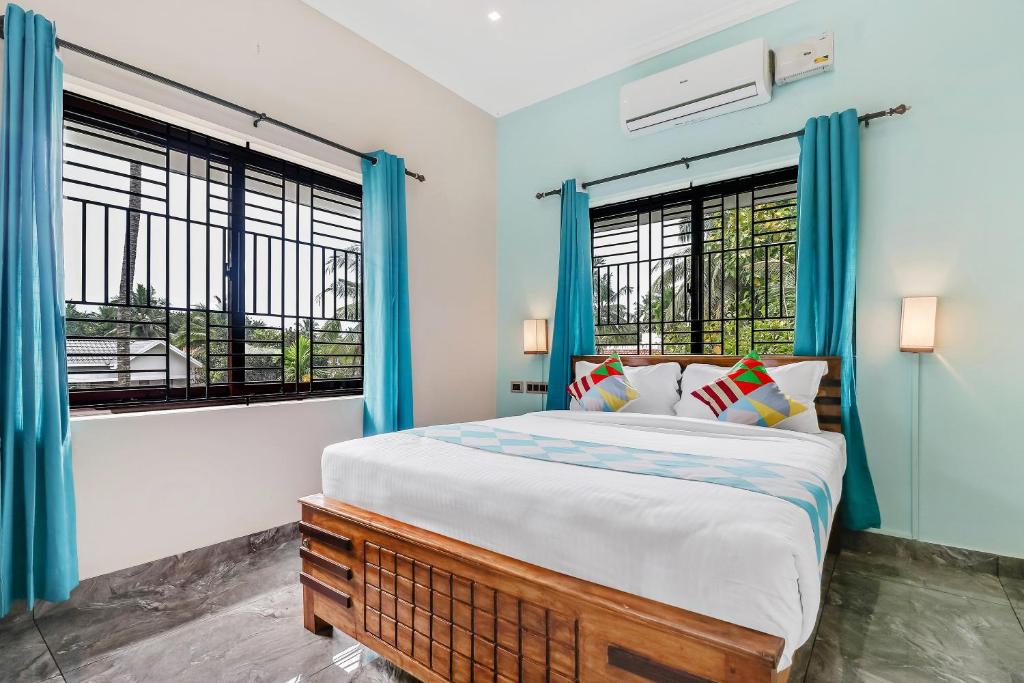 ein Schlafzimmer mit einem großen Bett und zwei Fenstern in der Unterkunft OYO Home Royal Salem in Kakkayam
