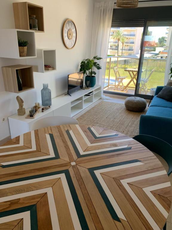 een woonkamer met een blauwe bank en een geometrisch tapijt bij Apartamento de estilo mediterráneo in Miami Platja