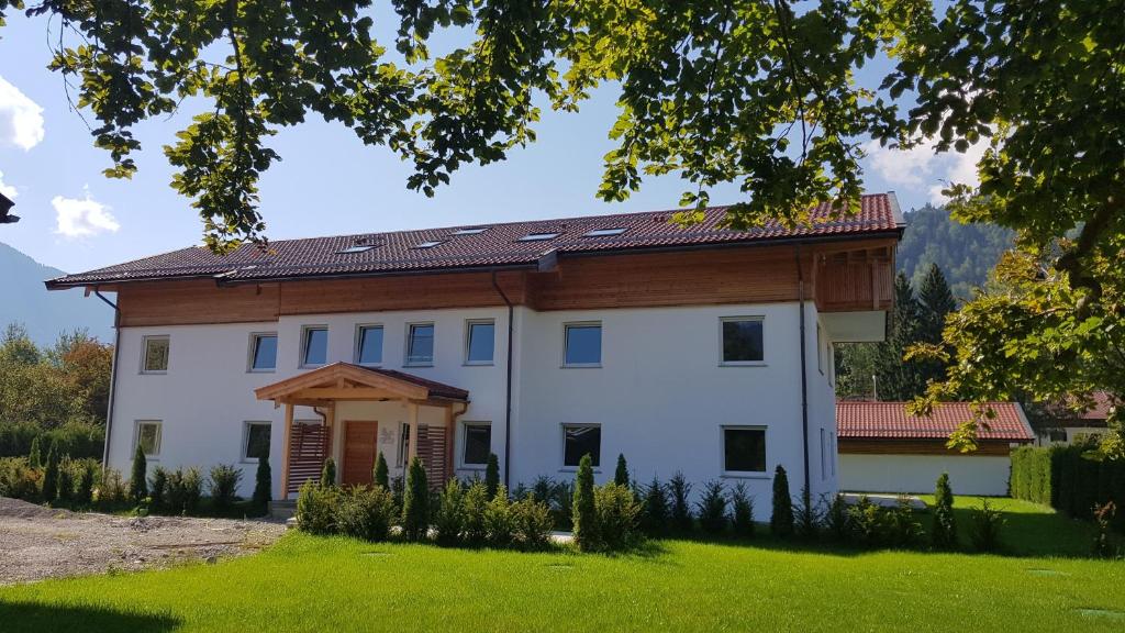 a large white house with a wooden roof at Ferienwohnungen Gottschlicht in Oberhof
