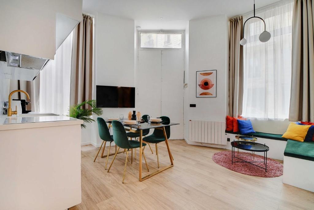 une cuisine et un salon avec une table et des chaises dans l'établissement Charming apartment 2BR- 4P - Rochechouart, à Paris