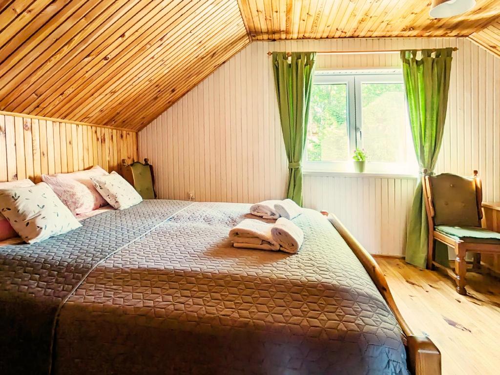 a bedroom with a large bed in a room at Różany Ogród - dom pod lasem, z widokiem na jezioro i kominkiem, rowery, łódka, rowerek wodny in Przezmark