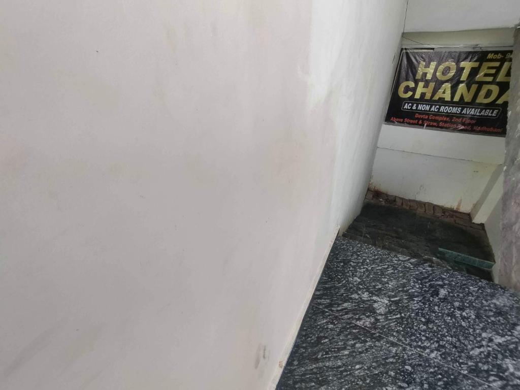 esquina de una habitación con un cartel en la pared en OYO 81285 Hotel Chanda, en Madhubani