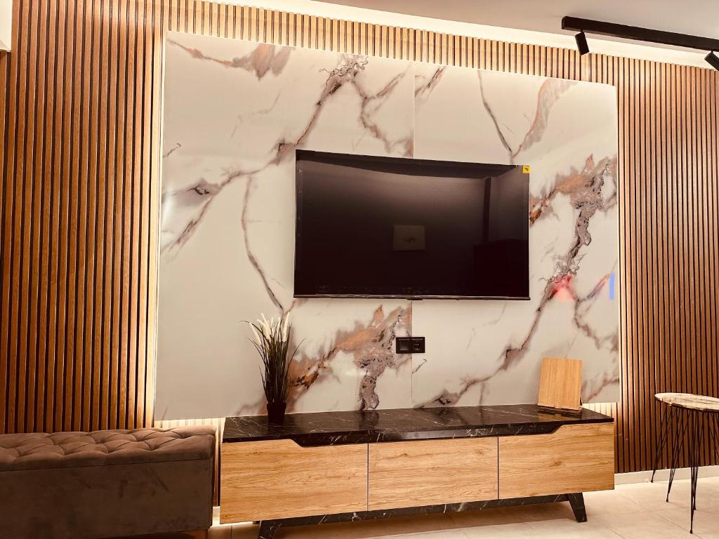 テッサロニキにあるM Boutique Apartmentsの大理石の壁にテレビ付きのリビングルーム