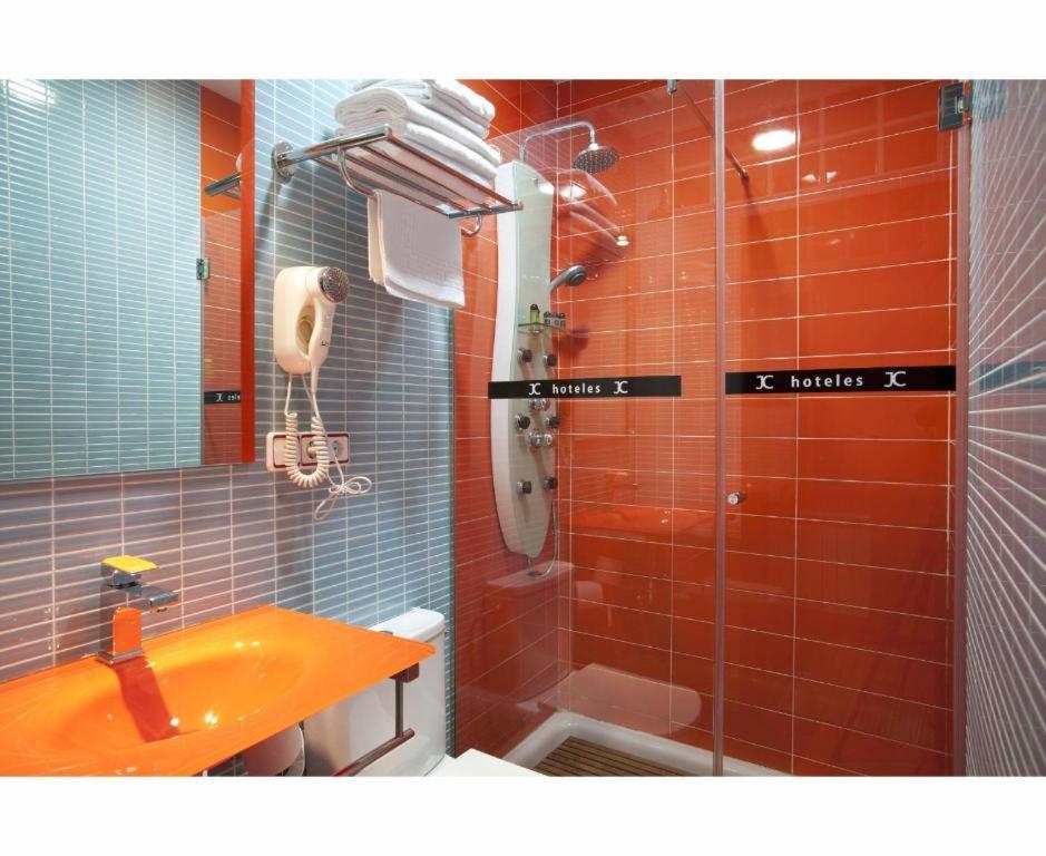 a bathroom with a sink and a shower with red tiles at JC Rooms Santo Domingo in Madrid