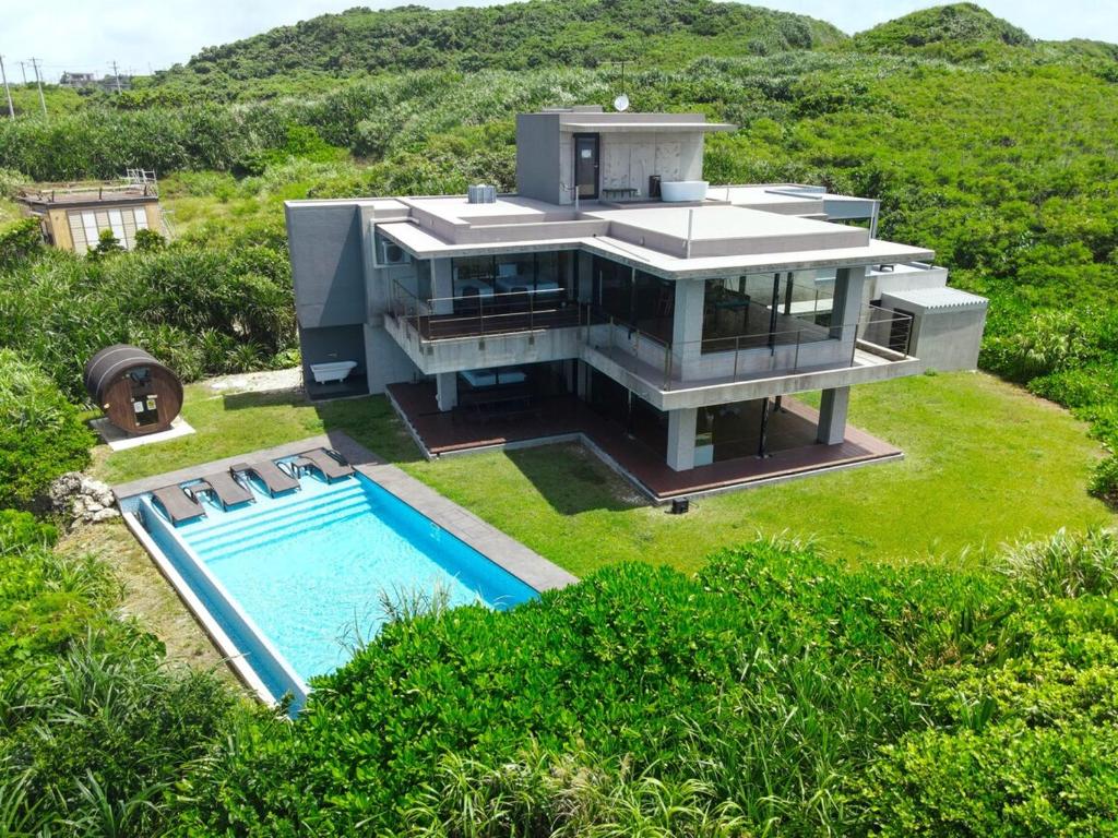 an aerial view of a house with a swimming pool at Castello do mare カステロディマーレ in Miyako Island