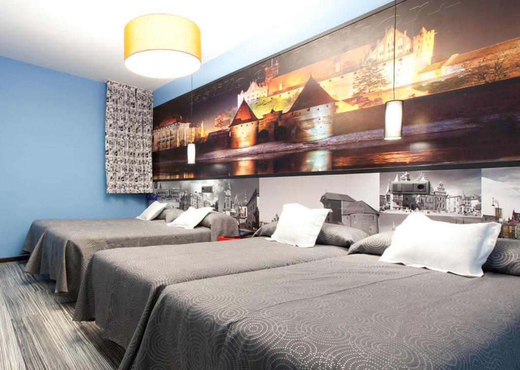 a room with two beds and a painting on the wall at JC Rooms Santo Domingo in Madrid