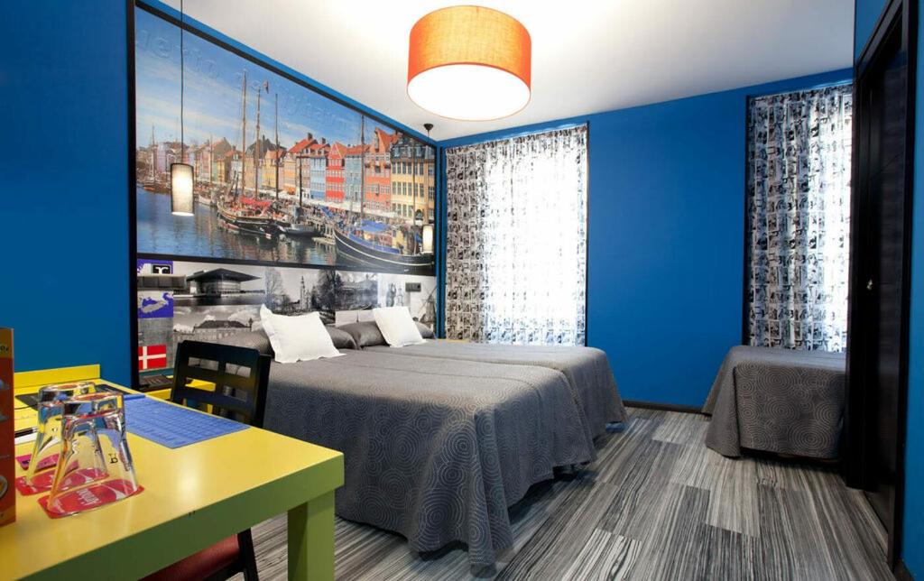 a bedroom with a bed and a painting on the wall at JC Rooms Santo Domingo in Madrid
