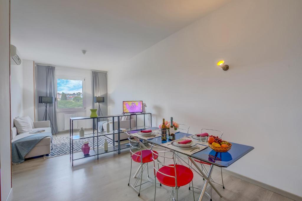 un soggiorno con tavolo e sedie rosse di Appartamento di Tommaso - Happy Rentals a Desenzano del Garda