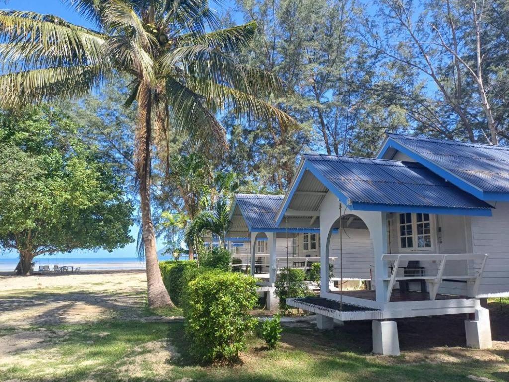 a cottage on the beach with a palm tree at PAN Beachfront Resort Krabi in Klong Muang Beach