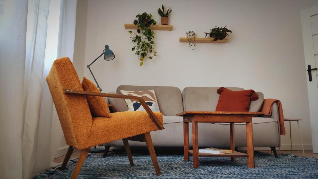 a living room with a couch and a table and a chair at Kwadrat i Kropka Apartament Zamość in Zamość