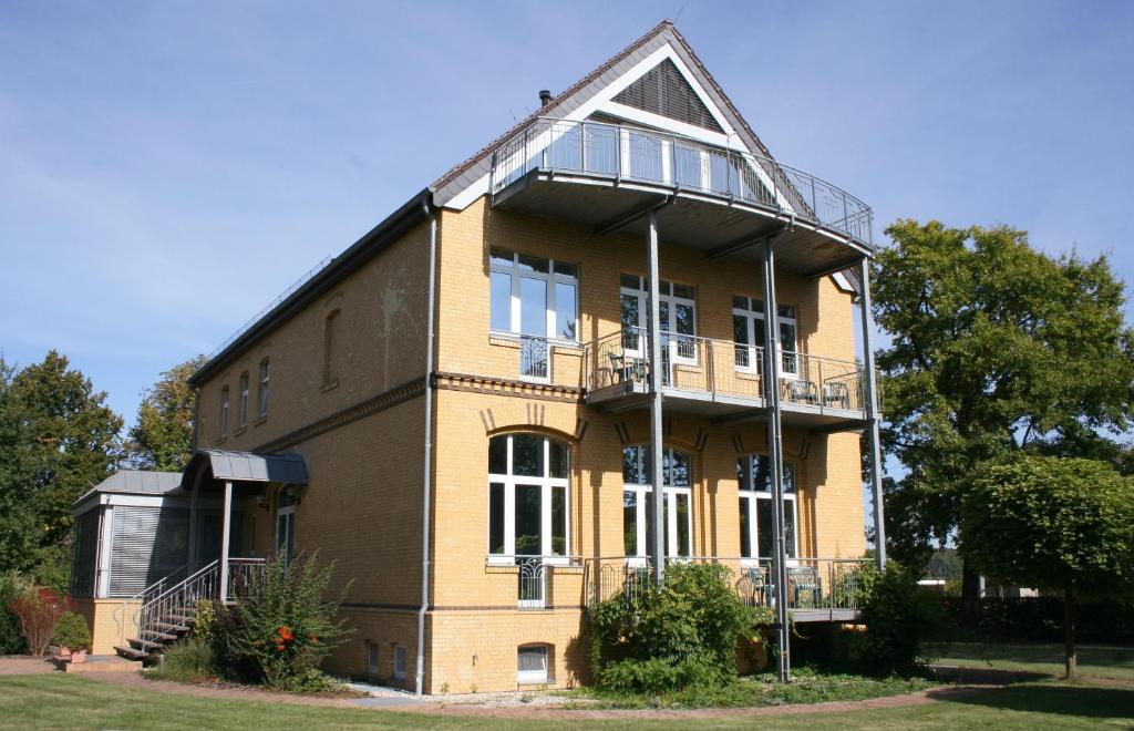 a large brick building with a balcony on it at Gästehaus am Lausitzring in Poley