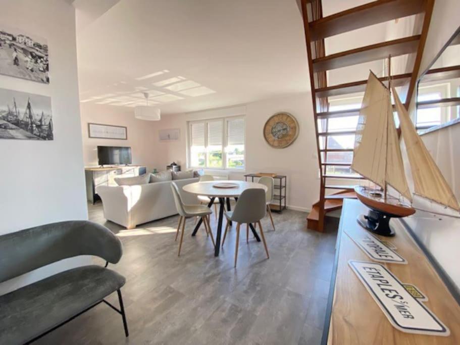 - un salon avec un canapé et une table avec un bateau dans l'établissement La Capitainerie Beau duplex face port de plaisance, à Étaples