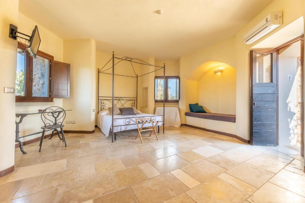 a bedroom with a bed and a table and chairs at Villetta Il Morige in Galatone