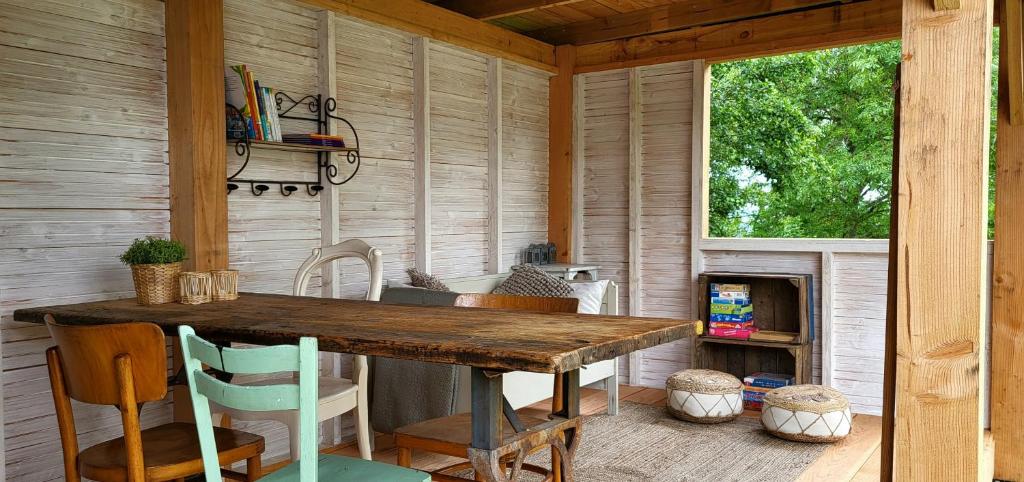 a dining room with a wooden table and a fireplace at Petit a Petit - gypsy wagons and Bell tents in the Bourgogne in Saisy