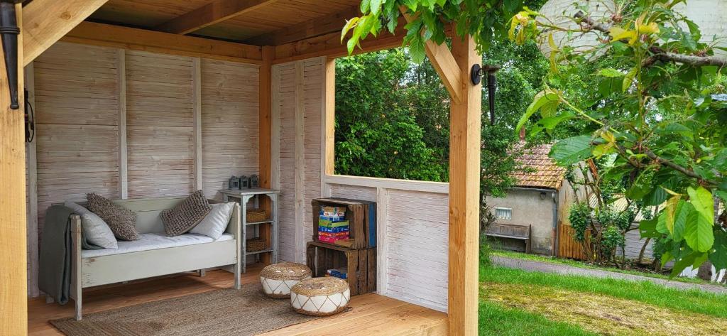 a screened in porch with a bench and a window at Petit a Petit - gypsy wagons and Bell tents in the Bourgogne in Saisy