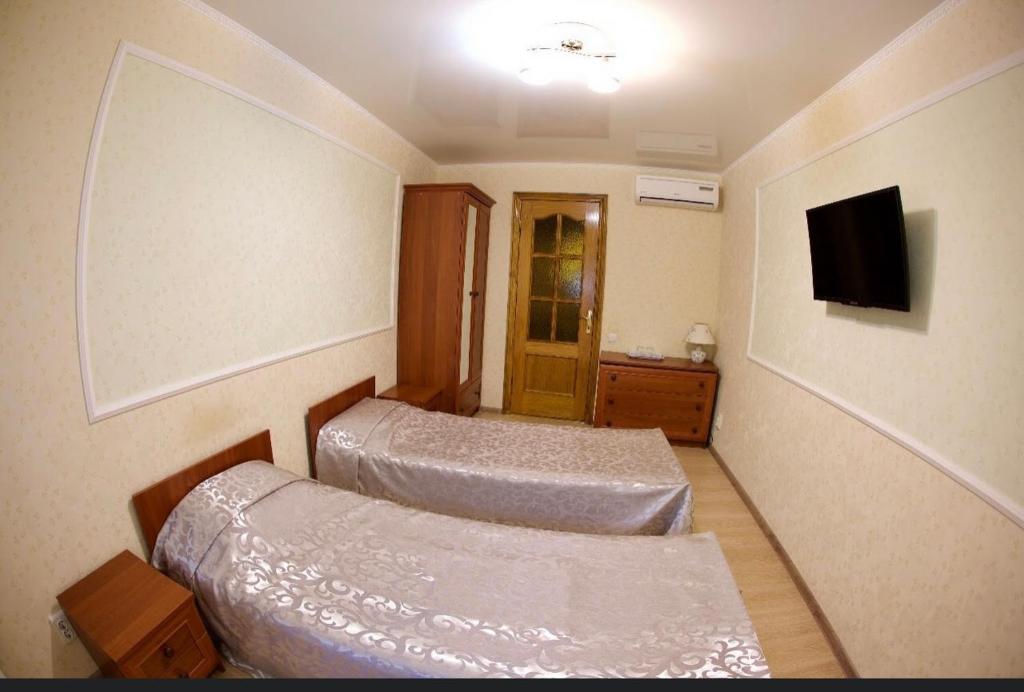 um quarto de hotel com duas camas e uma televisão em Vilari Odessa em Odessa