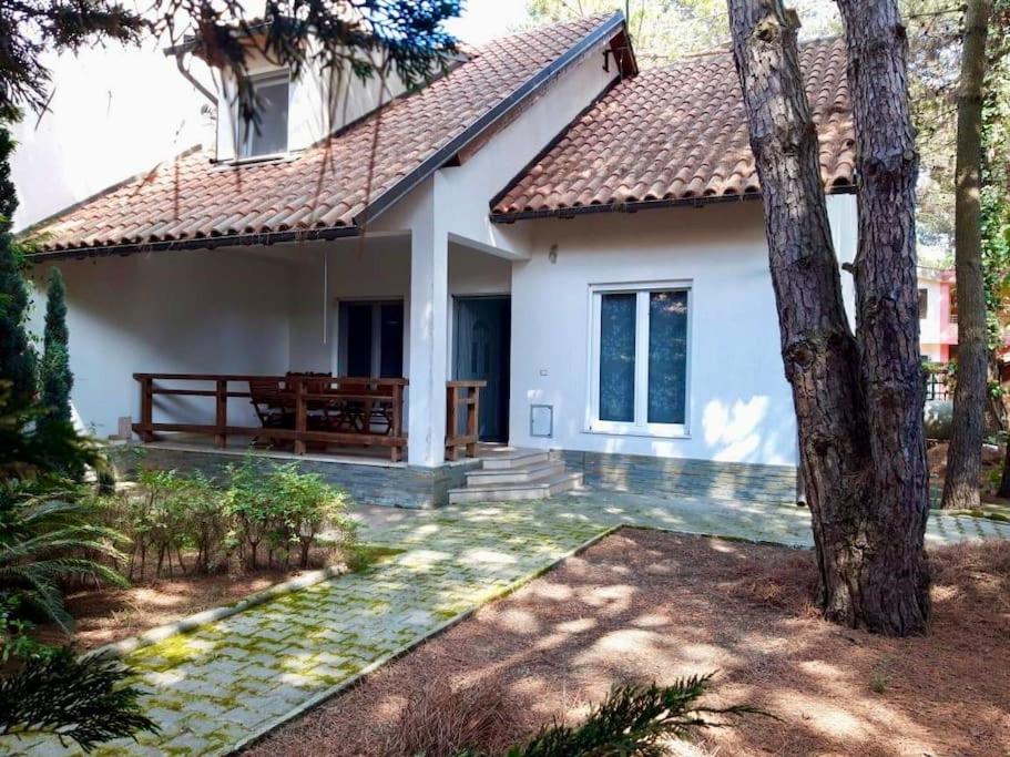 een wit huis met een bankje ervoor bij Beach Villa in Golem in Golem