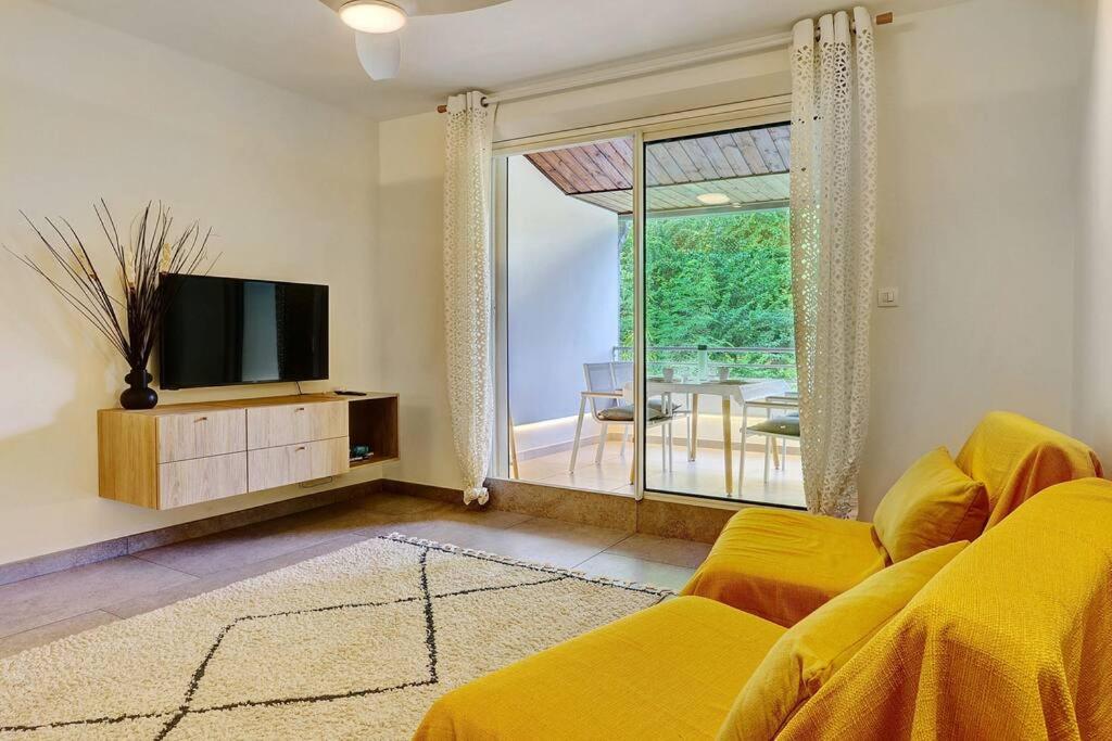 Saint-PaulにあるLe petit Lux du Lagon - La Saline les Bainsのリビングルーム(黄色のソファ、テレビ付)