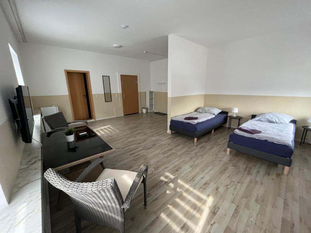 une chambre avec deux lits et un bureau et une chambre avec un canapé dans l'établissement MWM Gästehaus, à Meine