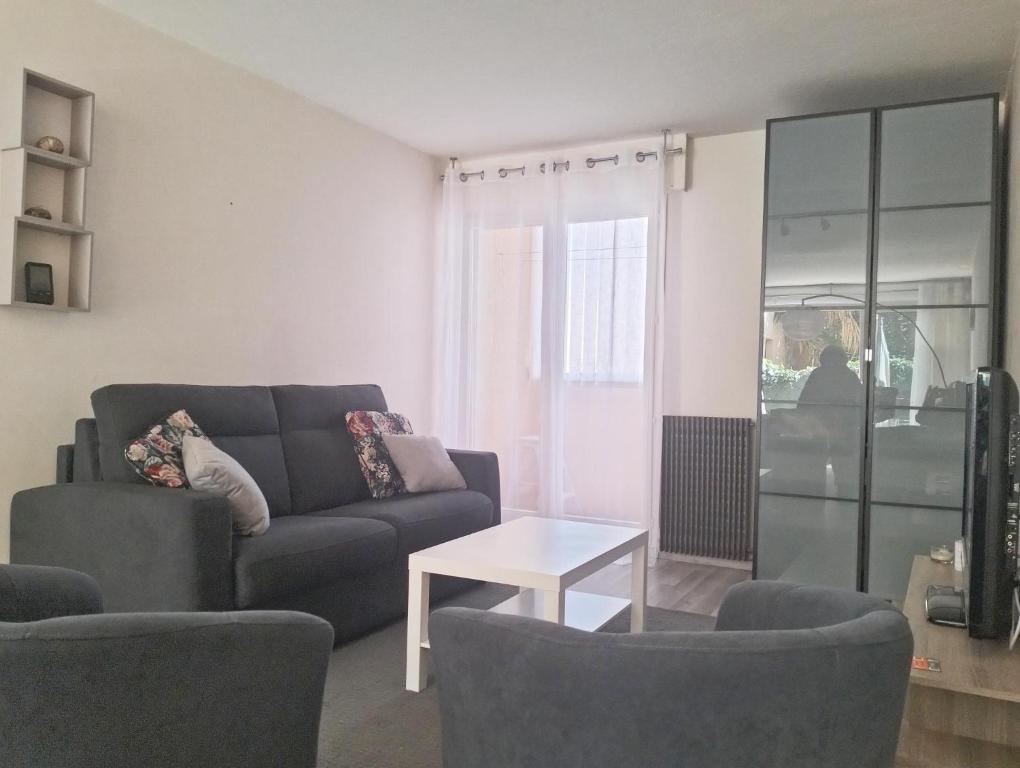 un salon avec un canapé, deux chaises et une table dans l'établissement Soleil Bleu, T2, 53 m2 - 15min à pied des plages, au Pradet