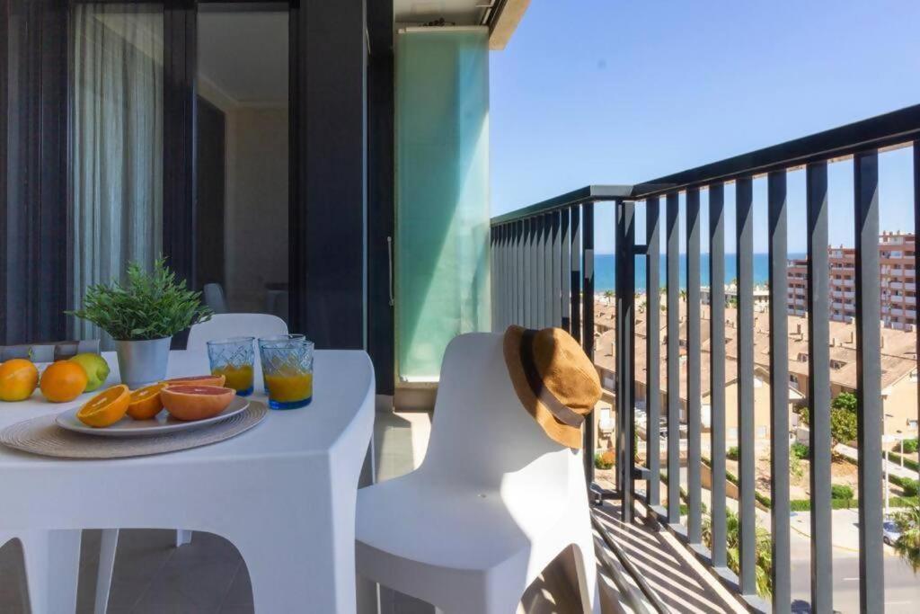 una mesa con un plato de naranjas en el balcón en Alboraya Apartamento con vista al mar y piscina en Valencia