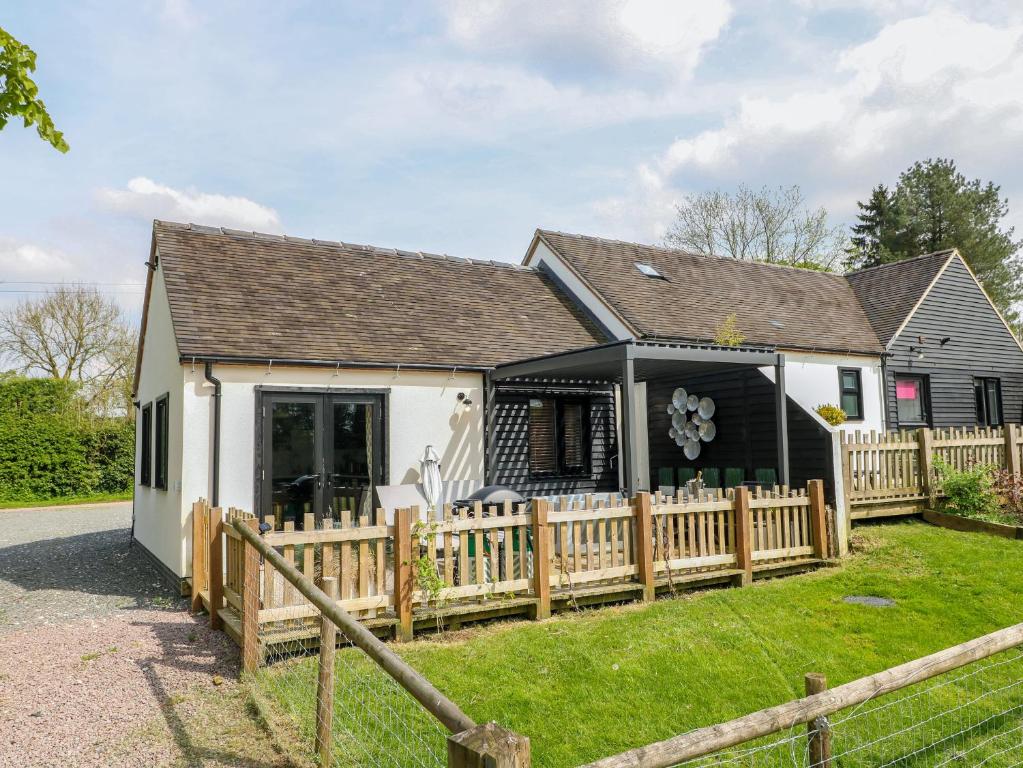 a house with a wooden fence in front of it at The Wood Shed, Bank Top Farm in Ashbourne