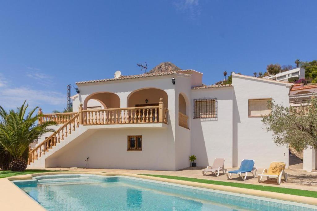 una villa con piscina e una casa di Chalet Los Olivos con piscina a Jávea