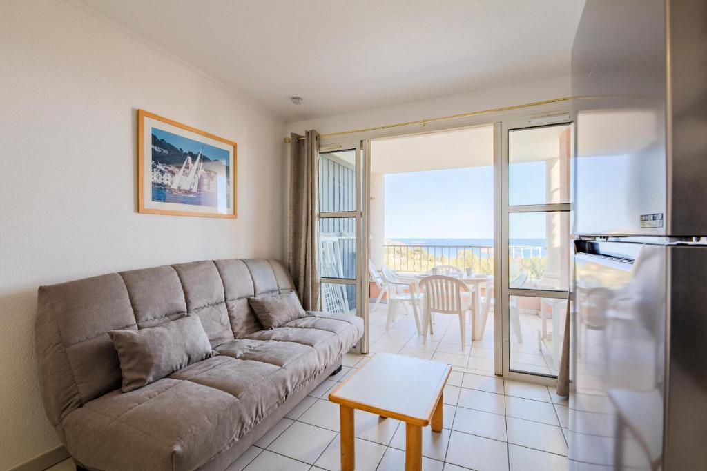 un salon avec un canapé et une table dans l'établissement Résidence le Hameau de Cap Esterel - maeva Home - Appartement 2 pièces 4 personnes - Sélection MAE-5654, à Saint-Raphaël