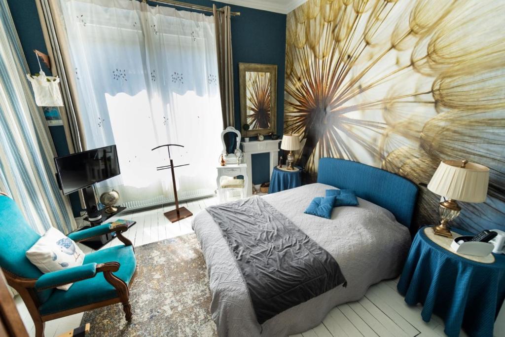Chambre Bounty cuisine privée, salle d'eau, terrasse, garage في Olliergues: غرفة نوم مع سرير مع لوحة كبيرة على الحائط