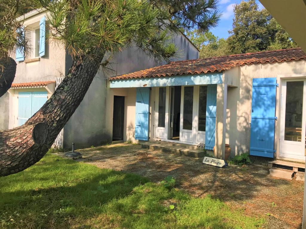 une maison avec un palmier devant dans l'établissement Entre les pins et l'océan, à La Tranche-sur-Mer