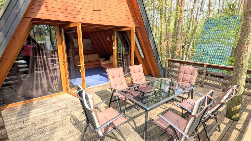 a screened in porch with chairs and a glass table at VIVA SOLE domek nr 8 in Skorzęcin