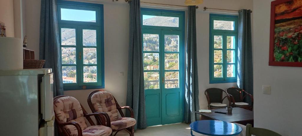 a room with two doors and a table and chairs at Andreas Apartments in Symi