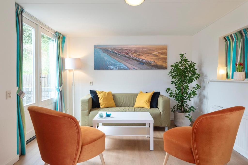 een woonkamer met een bank en een tafel bij Anne's Huisje with private parking in Zandvoort