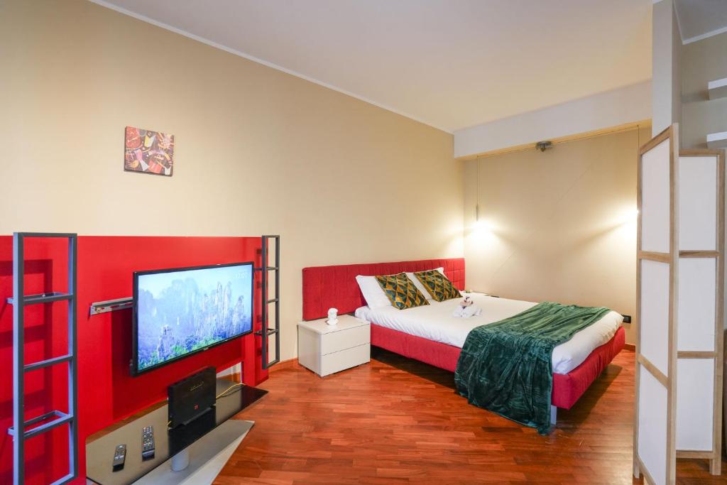 una camera da letto con un letto e una TV a schermo piatto di Loft Foscolo Open Space a Torino