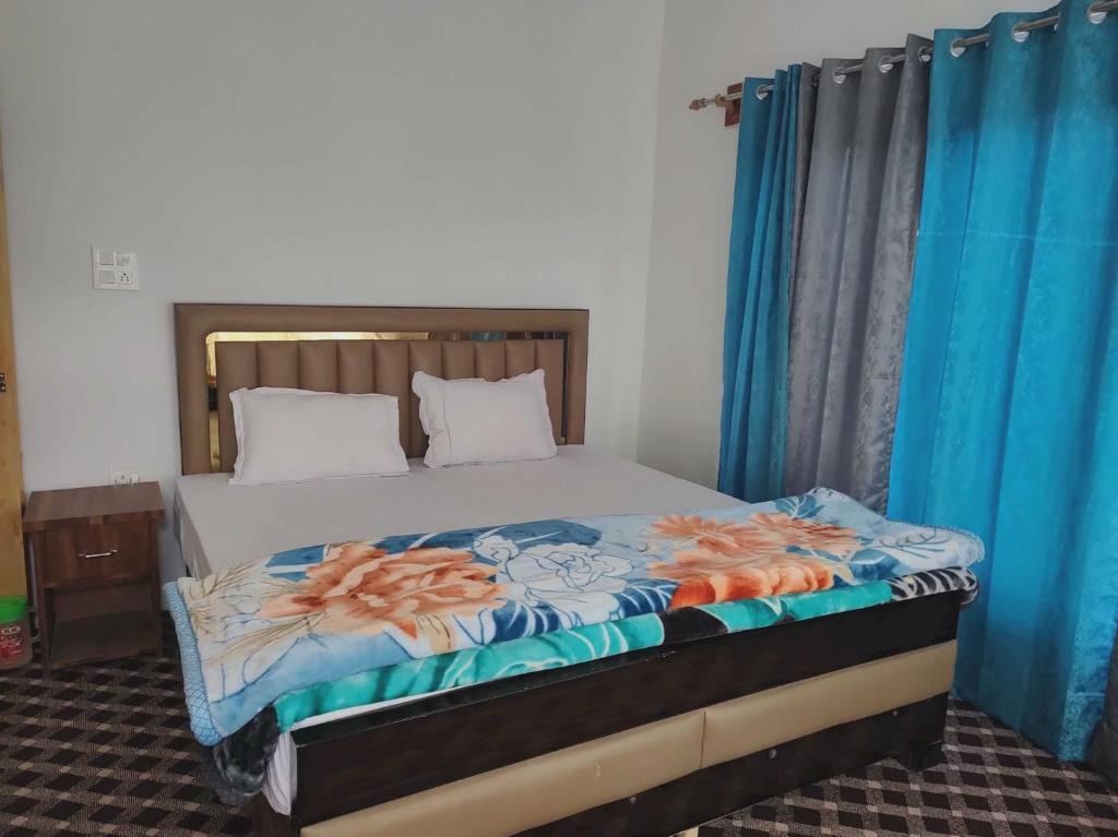 Cama en habitación con cortinas azules y cama sidx sidx sidx sidx en POP HOME 81129A Skayil Guest House en Nubra