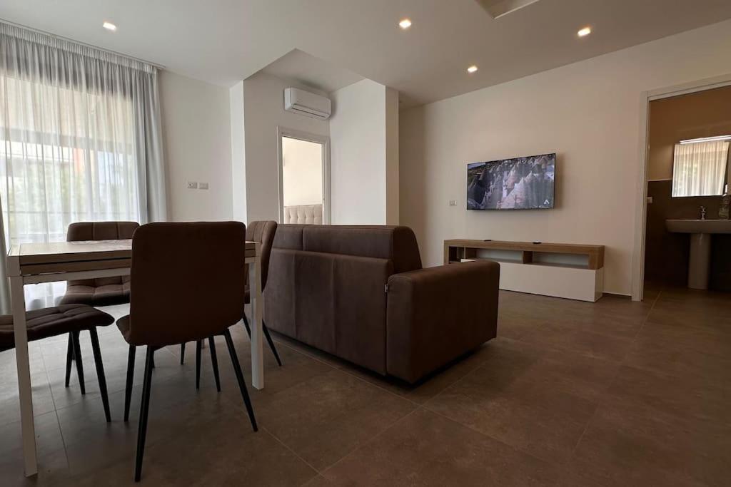 バーリにあるCconfortHotels Puglia Promenade Apartment 1のソファとテーブルと椅子のあるリビングルーム