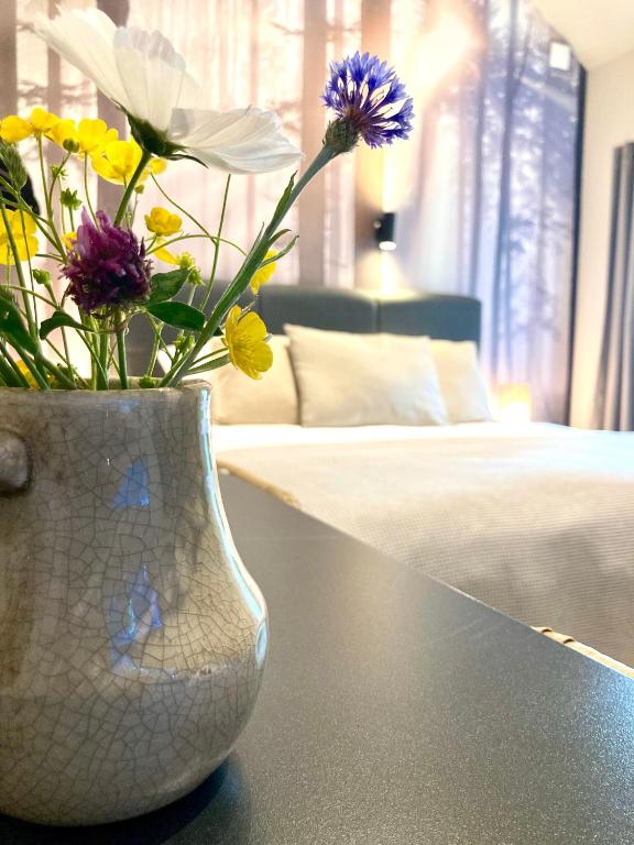 a vase with flowers on a table in a bedroom at Het Roerhofje in Herkenbosch