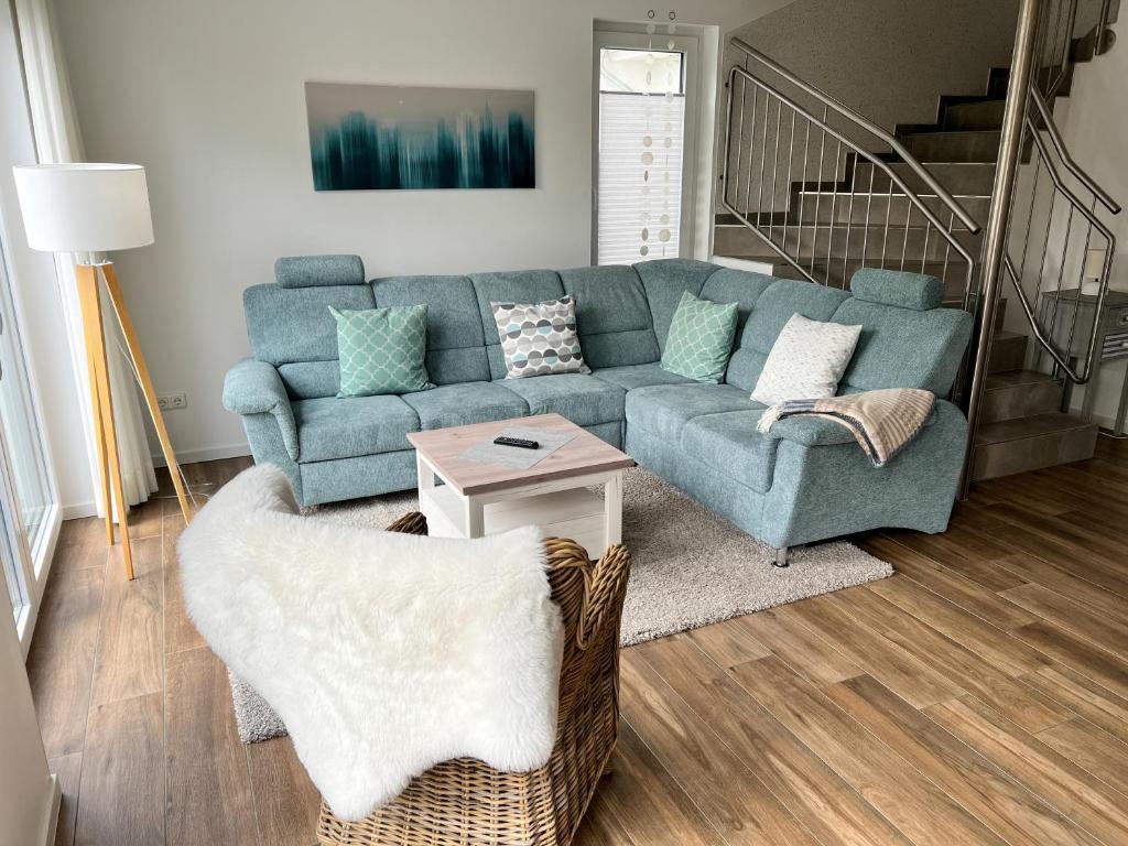 a living room with a blue couch and a table at Ferienhof Wübbold - 7Ost in Rieste